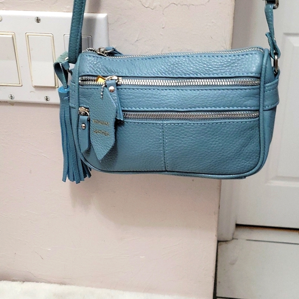 Light blue leather crossbody purse. Lots of pockets .